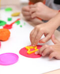 Nursery children playing with teacher in the classroom