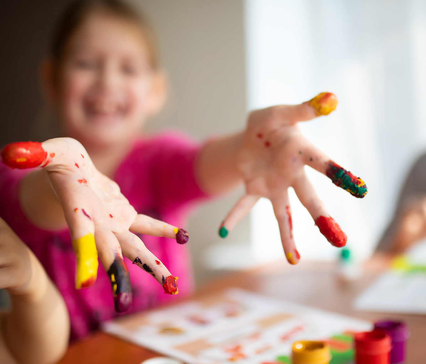 Two sisters little girls drawing with fingers on paper. Play, fun, childhood. Montessori school