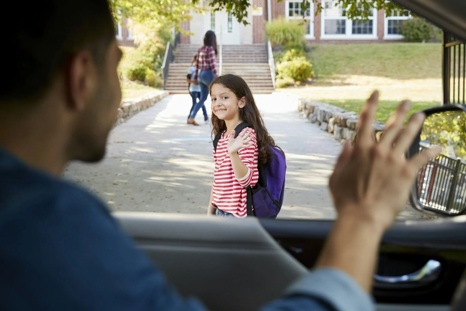 father-in-car-dropping-off-daughter-in-front-of-school-gates