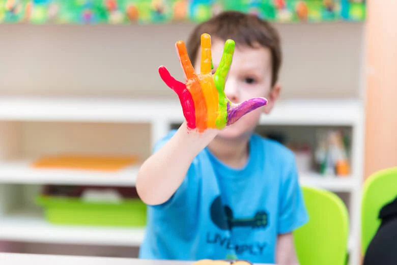 nv-daycare-kid-with-rainbow-hand-paint-780
